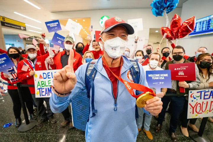 Jen Lee shows his gold medal after returning from the Paralympic Games.