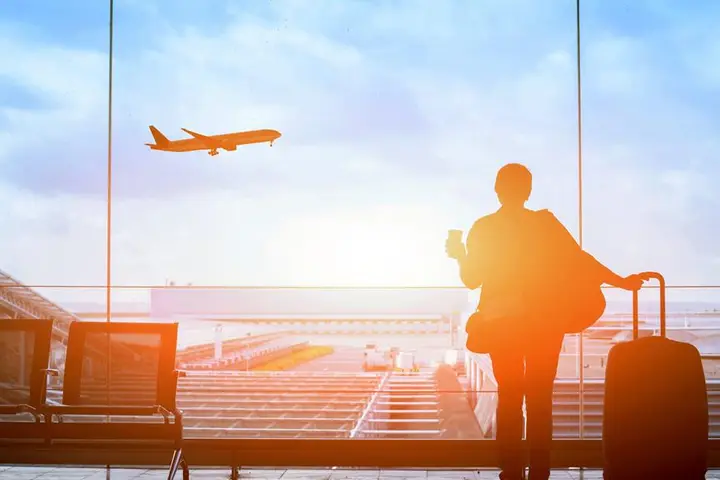 Customer watches plane at sunset