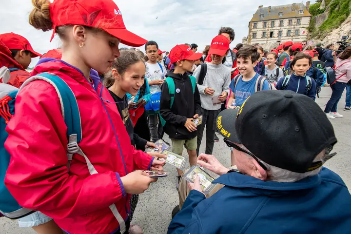 Raymond Dawkins passes his cards out to children at Mont St. Michel.