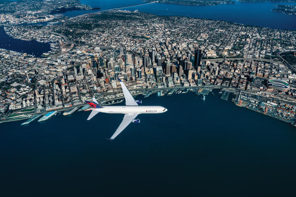A 767-300 flies over Seattle skyline.