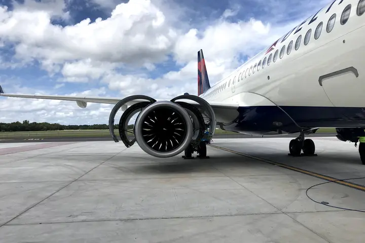 A220-300 aircraft on the tarmac with engine cowling open