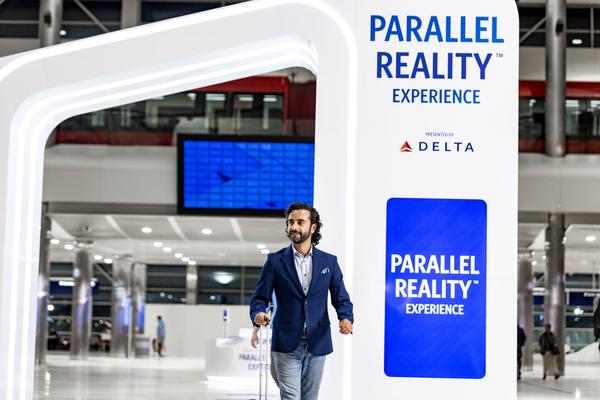 Male customer walking through Parallel Reality Experience archway at airport