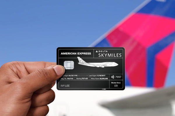Amex card in hand with plane tail