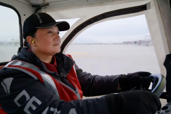 Delta Ramp Agent Sinai Pauni drives an electric bag tractor at Salt Lake City International Airport (SLC).