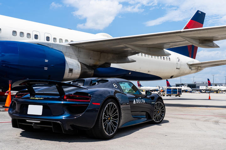 A Porsche 918 Spyder waits on the ramp to escort a Delta customer to a connecting flight. 