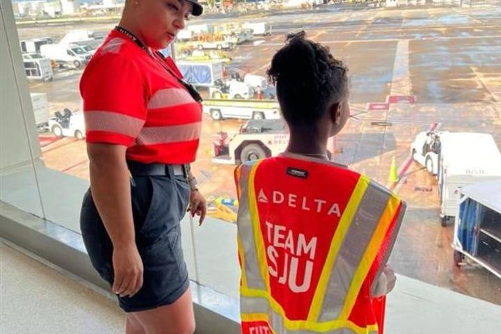 A Delta employee talks to a child at San Juan Airport as part of a special initiative to inspire excitement about aviation.