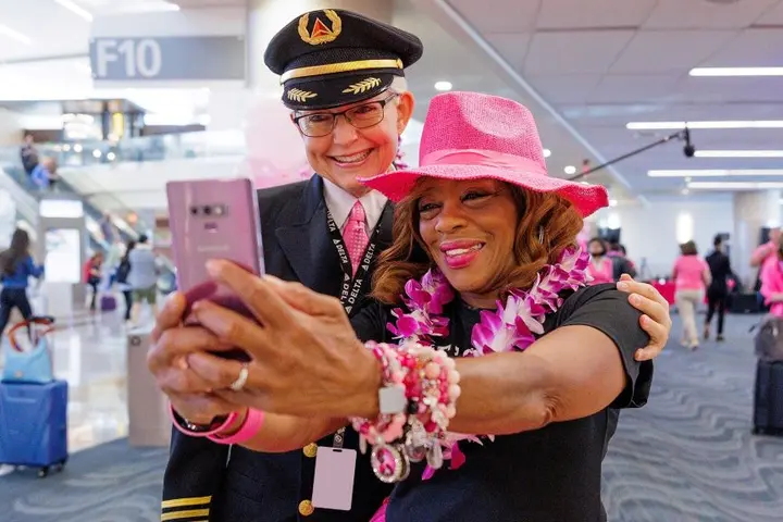Delta employees pose for a photo before boarding Delta's Breast Cancer One charter