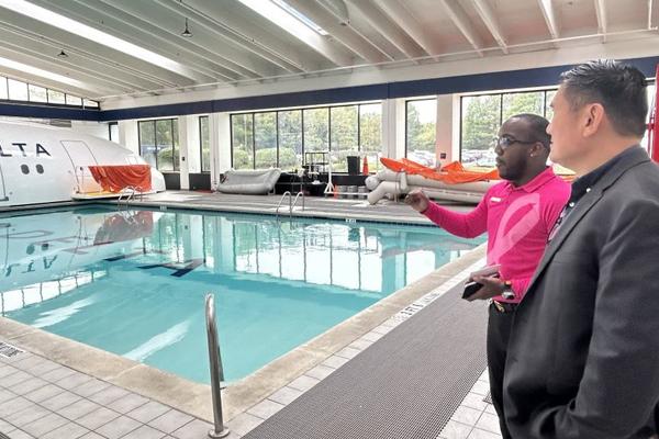 A Delta technical facilitator gives Todd O., Delta's most frequent flyer, greater insight into the rigorous flight attendant training sessions overlooking the emergency diving pool. 