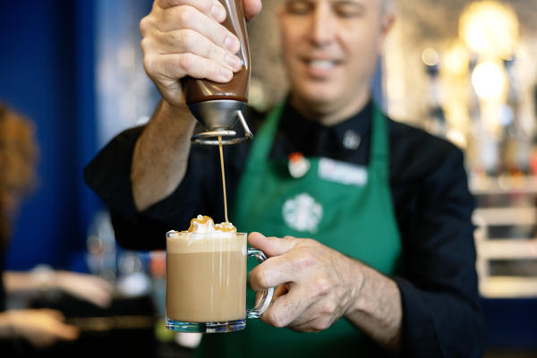 A Starbucks barista in the Delta Lounge prepares a specialty Dulce de Leche latte, a flavor exclusive to Latin American Starbucks locations.