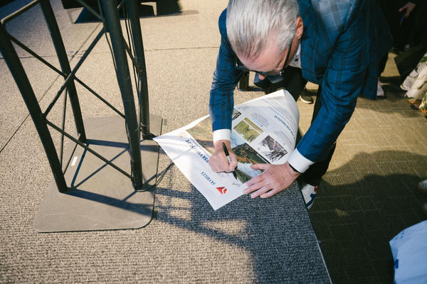 Delta CEO Ed Bastian autographs a newspaper after his panel at SXSW 2024.