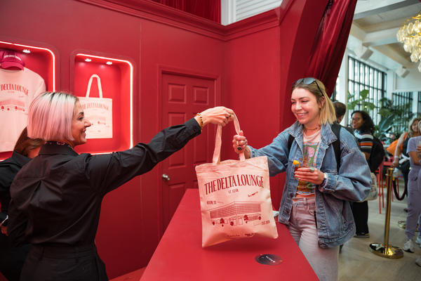 A Delta Lounge attendee receives a limited-edition Delta x SXSW canvas tote bag at the Gifting Salon during SXSW 2024.