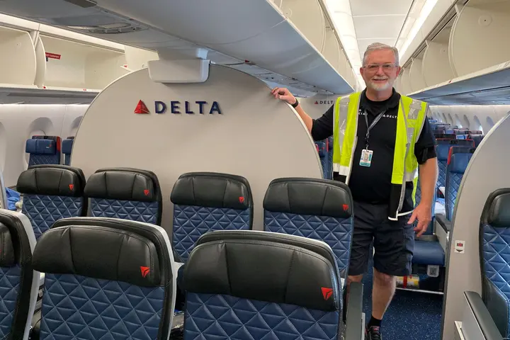 Tracy Rawls, Lead Aviation Maintenance Technician on the Delta TechOps Cabin Maintenance Team, stands on board an airplane.