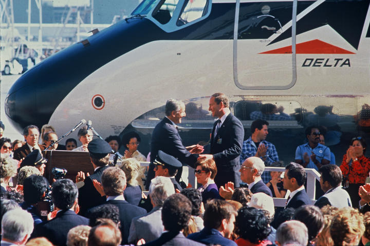 Former Delta CEO Jerry Grinstein stands before a crowd at the merger of Delta and Western Airlines in 1987.