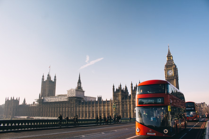 A double-decker bus rides past the Palace of Westminster in London