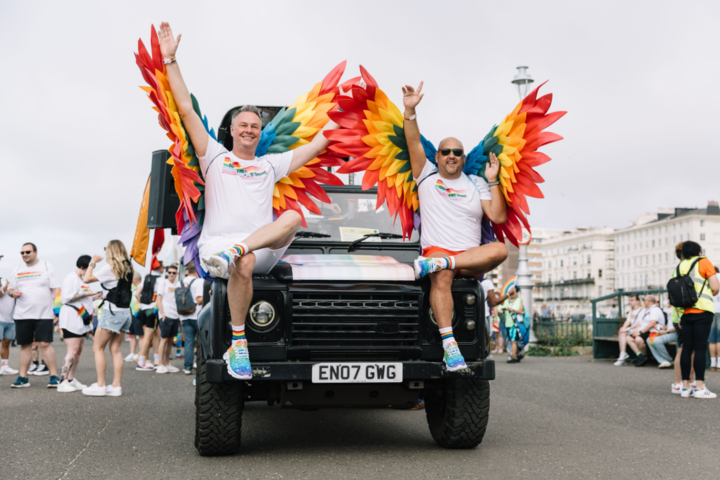 Two people wear rainbow wings for the Brighton & Hove Pride parade