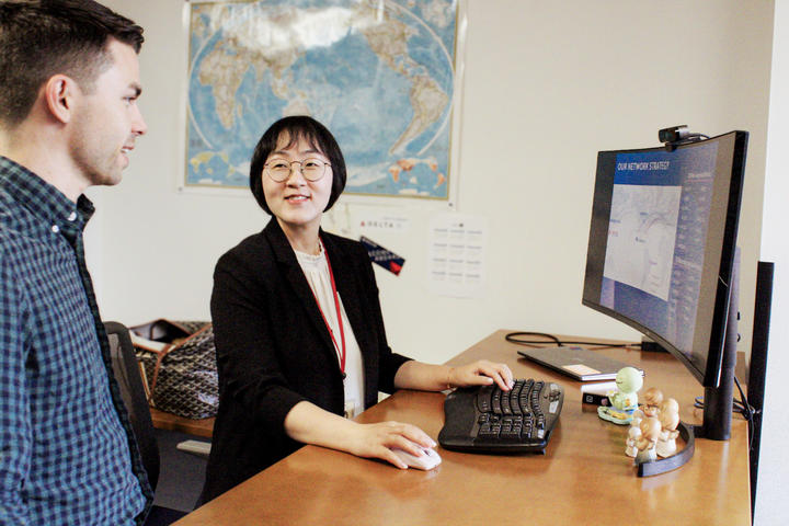 Jooyoung Kim, Director – International Network Planning, confers with a colleague.