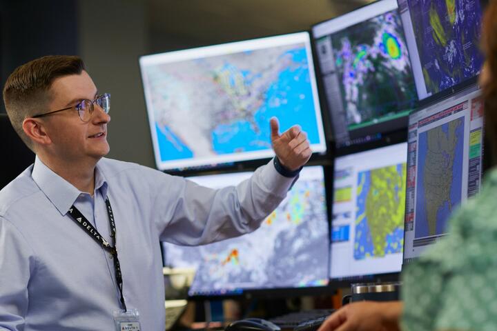 A meteorologist sits in front of multiple screens inside Delta's Operations & Customer Center