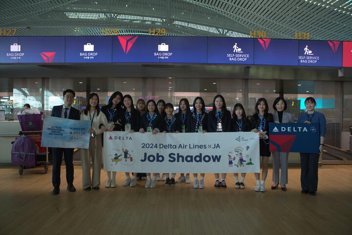 High school students pose in ICN Airport to commemorate their job shadowing experience with Delta and Junior Achievement.