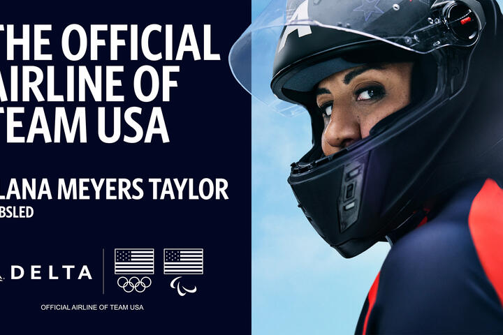 Promotional graphic with text reading ‘The Official Airline of Team USA’ and ‘Elana Meyers Taylor – Bobsled,’ alongside Delta, Olympic, and Paralympic logos. Bobsled athlete in a helmet and suit on right side of the image