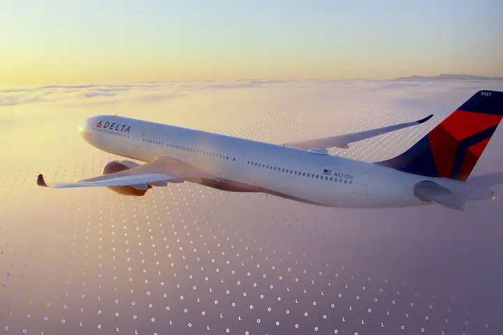 A Delta jet flies above a cloud layer at sunset, with a faint digital grid pattern overlaid across the sky.