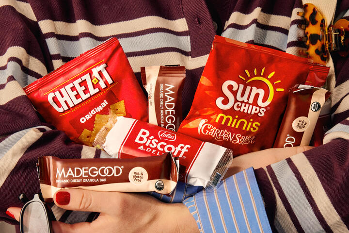 Someone holds an armful of snack served on Delta flights