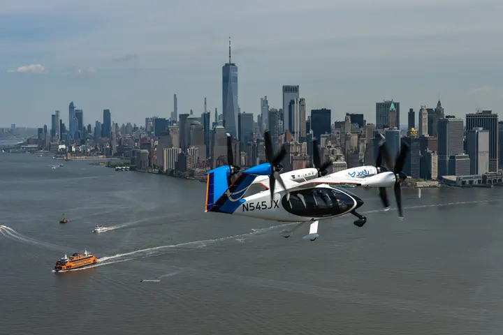 Joby electric air taxi flying over the Hudson River with the New York City skyline in the background.