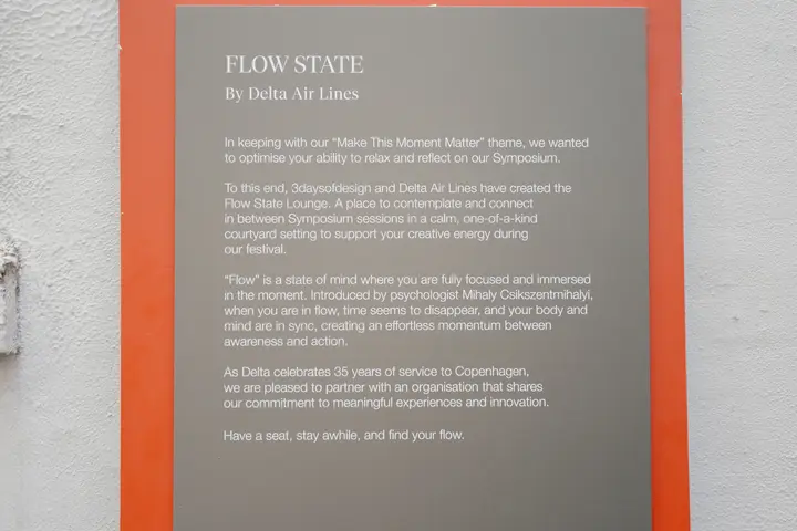 Poster on a wall reading “3daysofdesign” with a “Flow State by Delta Air Lines” description and event program details below.