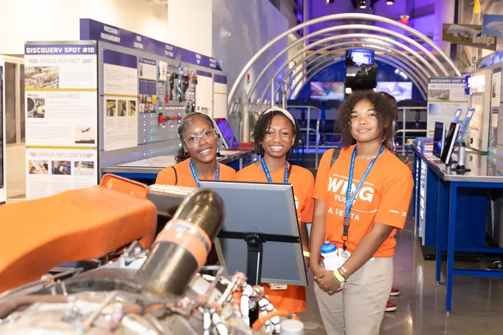 WING Flight participants pose among interactive aviation exhibits at Flight Works Alabama.
