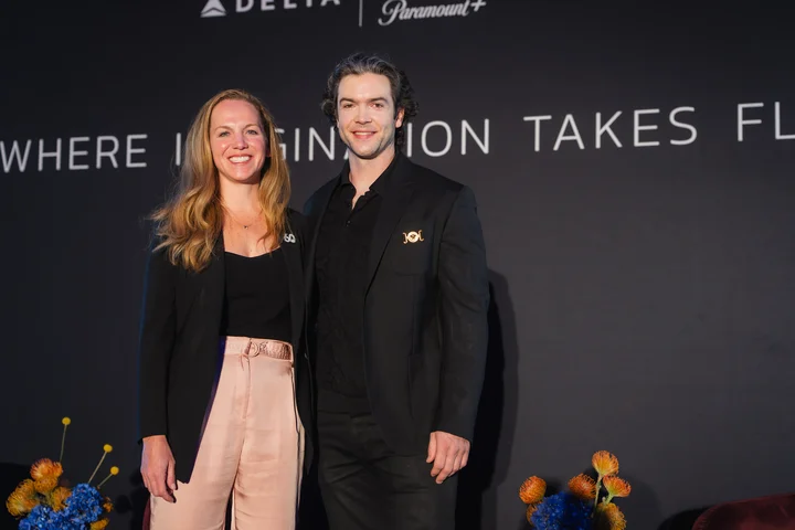 Delta and Paramount+ event attendees pose in front of a backdrop reading “Where Imagination Takes Flight.”