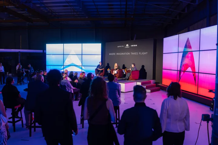 Audience members watch a panel discussion onstage at a Delta and Paramount+ Star Trek 60 event.