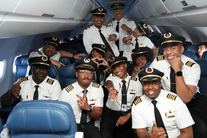 Delta pilots pose together in the aircraft cabin during the 26th annual DREAM Flight.
