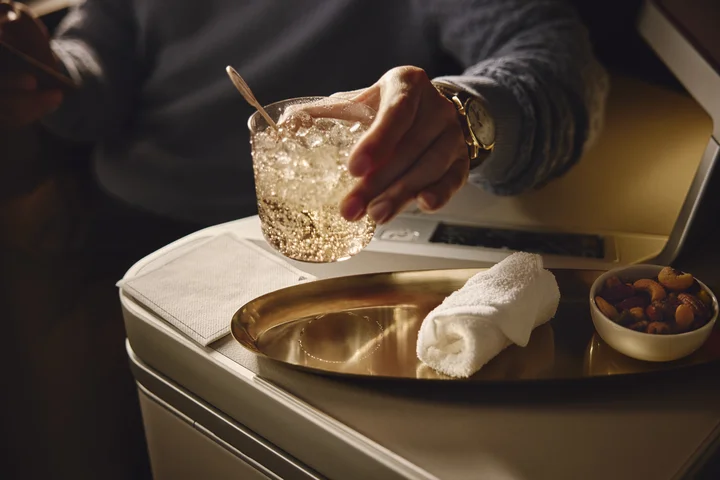 Beverage and mixed nuts served on a tray table in a Delta One suite.