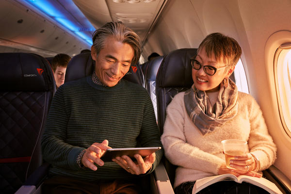 Two people use a tablet while seated in Delta Comfort+