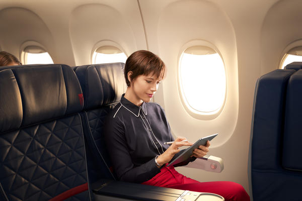A person uses a tablet, connected to Wi-Fi, while seated in Delta's domestic first class cabin.