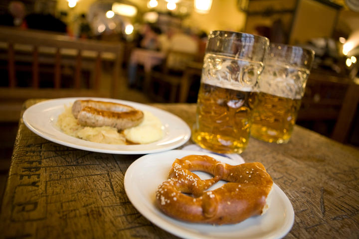 A pretzel and sausage with beer.