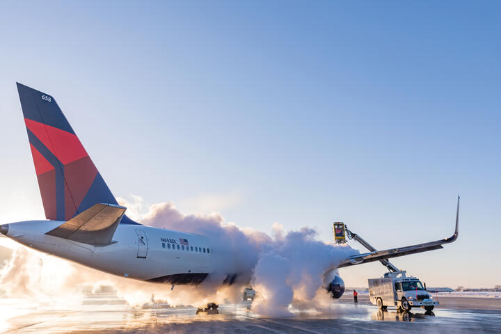 A 757-200 is deiced on a runway.