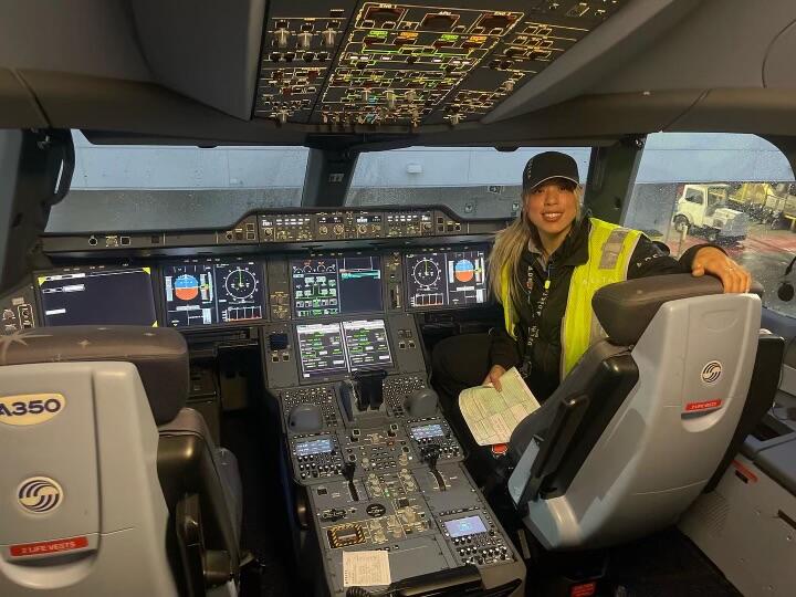 Delta TechOps employee Jessie Hekimian sits in the flight deck of an airplane.