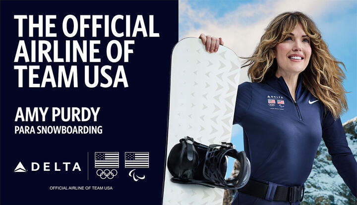 Promotional graphic with text reading ‘The Official Airline of Team USA’ and ‘Amy Purdy – Para Snowboarding,’ along with Delta, Olympic and Paralympic logos. On the right, athlete in navy jacket holds a snowboard against a snowy mountain backdrop