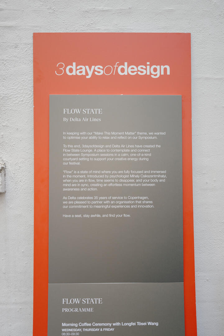 Poster on a wall reading “3daysofdesign” with a “Flow State by Delta Air Lines” description and event program details below.