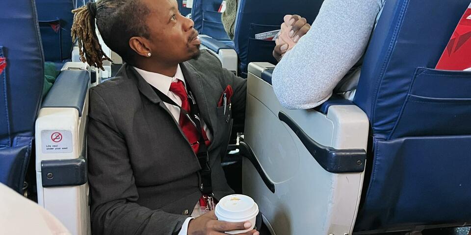 Endeavor Air flight attendant Floyd Dean-Shannon comforts a nervous customer during a Delta Connection flight from Charlotte to New York.