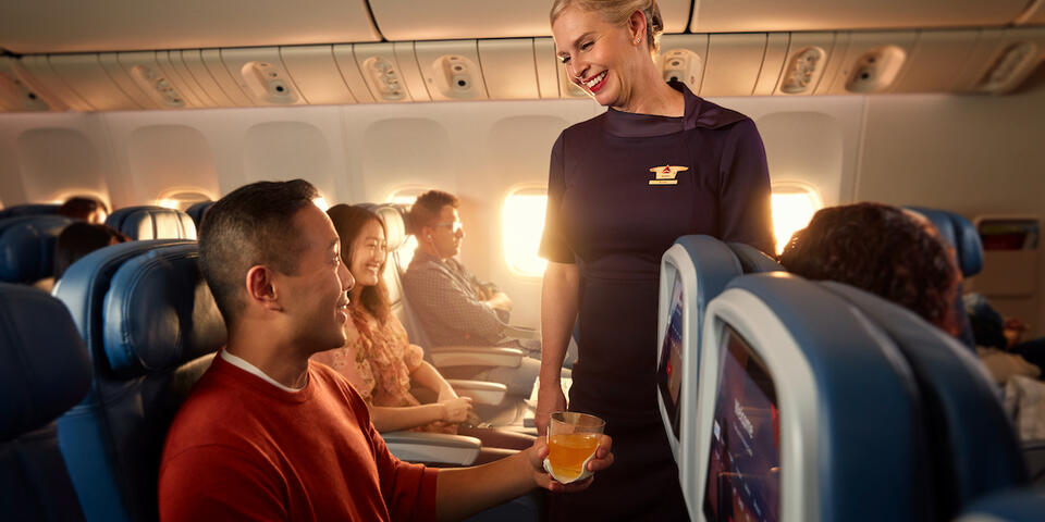 A Delta flight attendant helps a customer on board their flight.