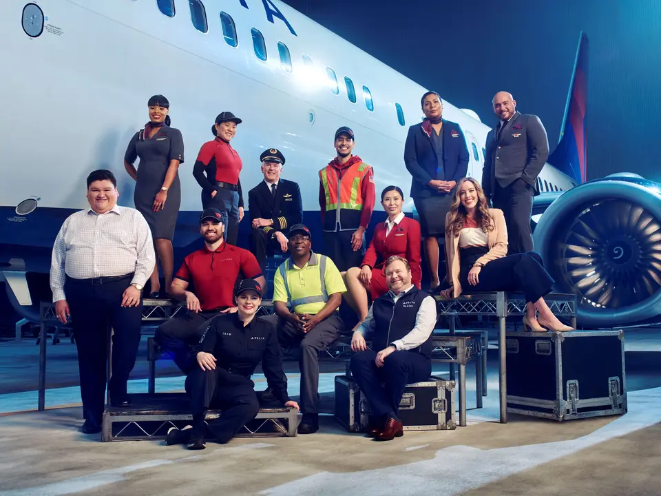 Employees from across Delta's divisions pose in front of a plane in 2023.