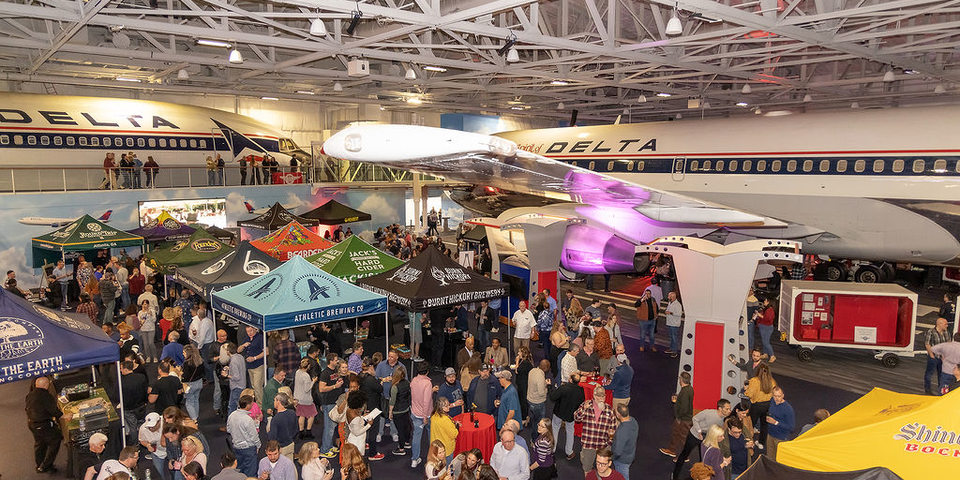 People attend the Hops in the Hangar event in the Delta Flight Museum.
