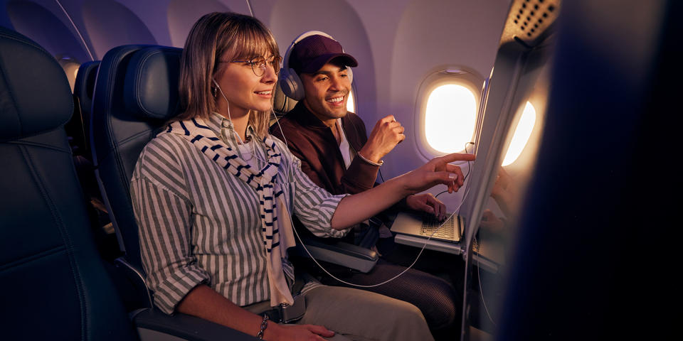 Customers browse seatback entertainment on a Delta flight.
