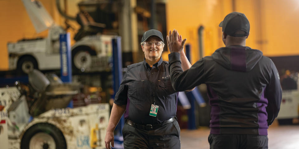 Delta employees high-five at work.