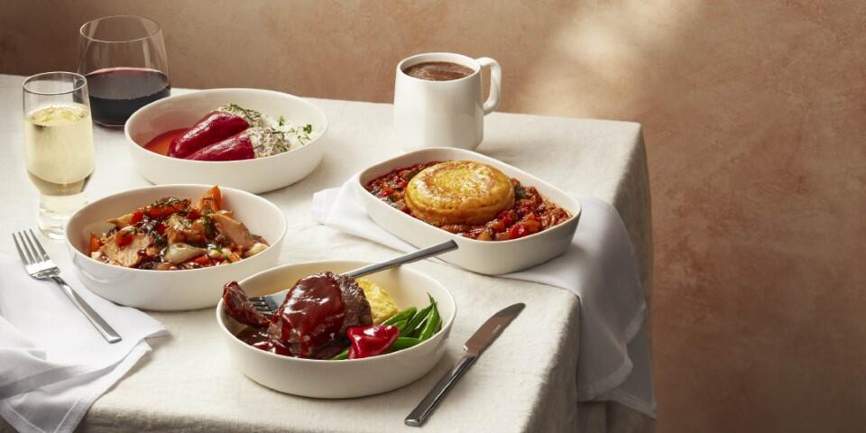 Various plated meals displayed on a table with a white tablecloth.