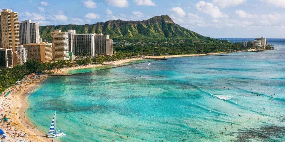 A skyline overlooking a beach and turquoise waters in Hawaii.