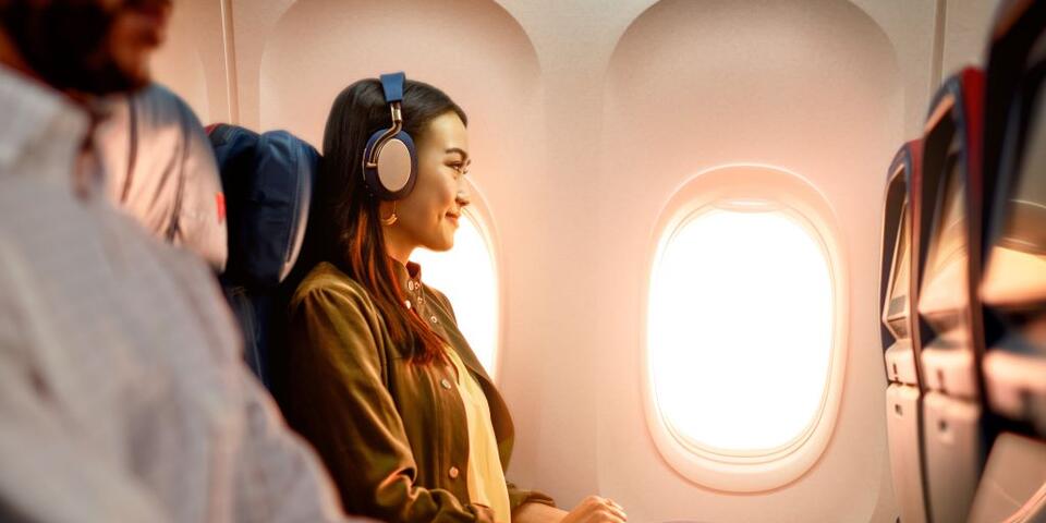 A woman enjoys In-Flight Entertainment onboard a Delta flight.