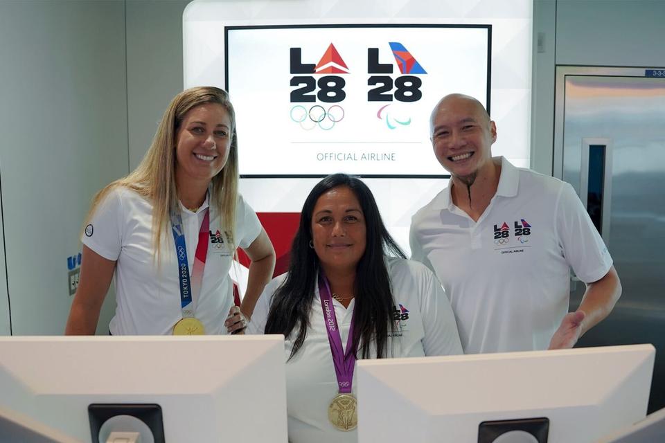 U.S. Olympians April Ross (left) and Brenda Villa (center), and U.S. Paralympian Jen Lee (right) pose for a photo at LAX near Delta's co-created LA28 logo on Sept. 29, 2022.