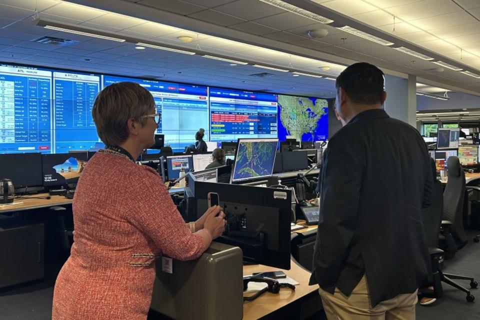 A Delta employee shows Todd O., Delta's most frequent flyer, around the OCC, the heartbeat of the operation with constant flight, emergency and weather tracking. 